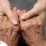 Younger hands hold older ones, representing the care and compassion of caregiving and how caregivers can help, even in ways like implementing stroke prevention strategies.