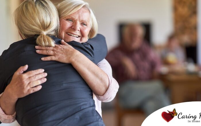 An older woman smiles as a younger woman visits her and hugs her, showing the effect that acts of kindness can have on senior loved ones.