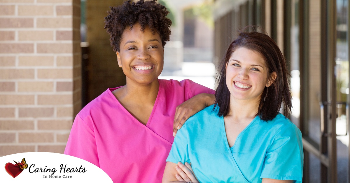 2 smiling women in scrubs represent RN supervisors and the good environment that can be promoted when they work together with caregivers for quality client care.