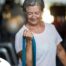 An older woman uses a resistance band to exercise, representing how staying active can help older adults keep their blood pressure in a healthy range.